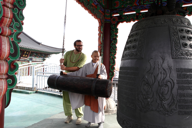 A guest participating in Myogaksa Temple's evening bell striking ritual in Seoul. 
