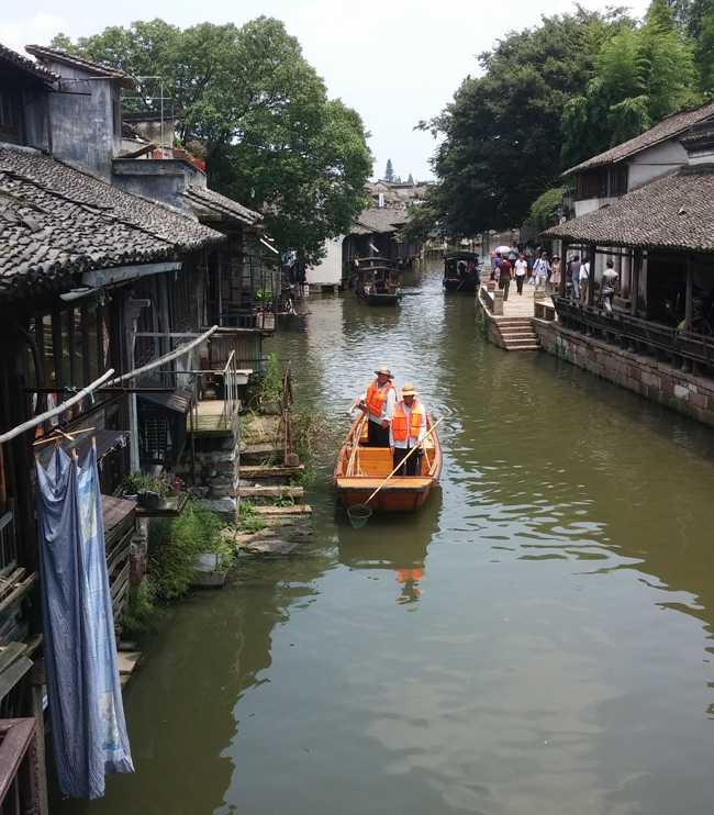 Locals boating on the jade-hued river in Wuzhen, an ancient Chinese water town located on the banks of the Grand Canal.