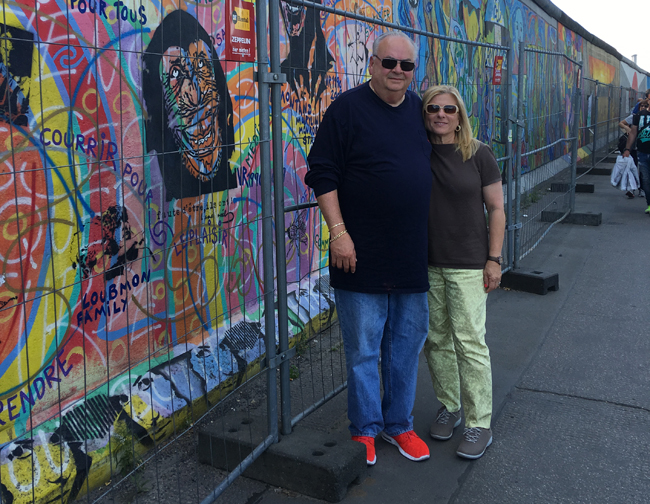Lisa and her husband, Andre Perlo, visiting the Berlin Wall.