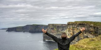A traveler taking in the Cliffs of Moher on the Ireland Singles Hopper itinerary. (Photo courtesy of Tenon Tours.)
