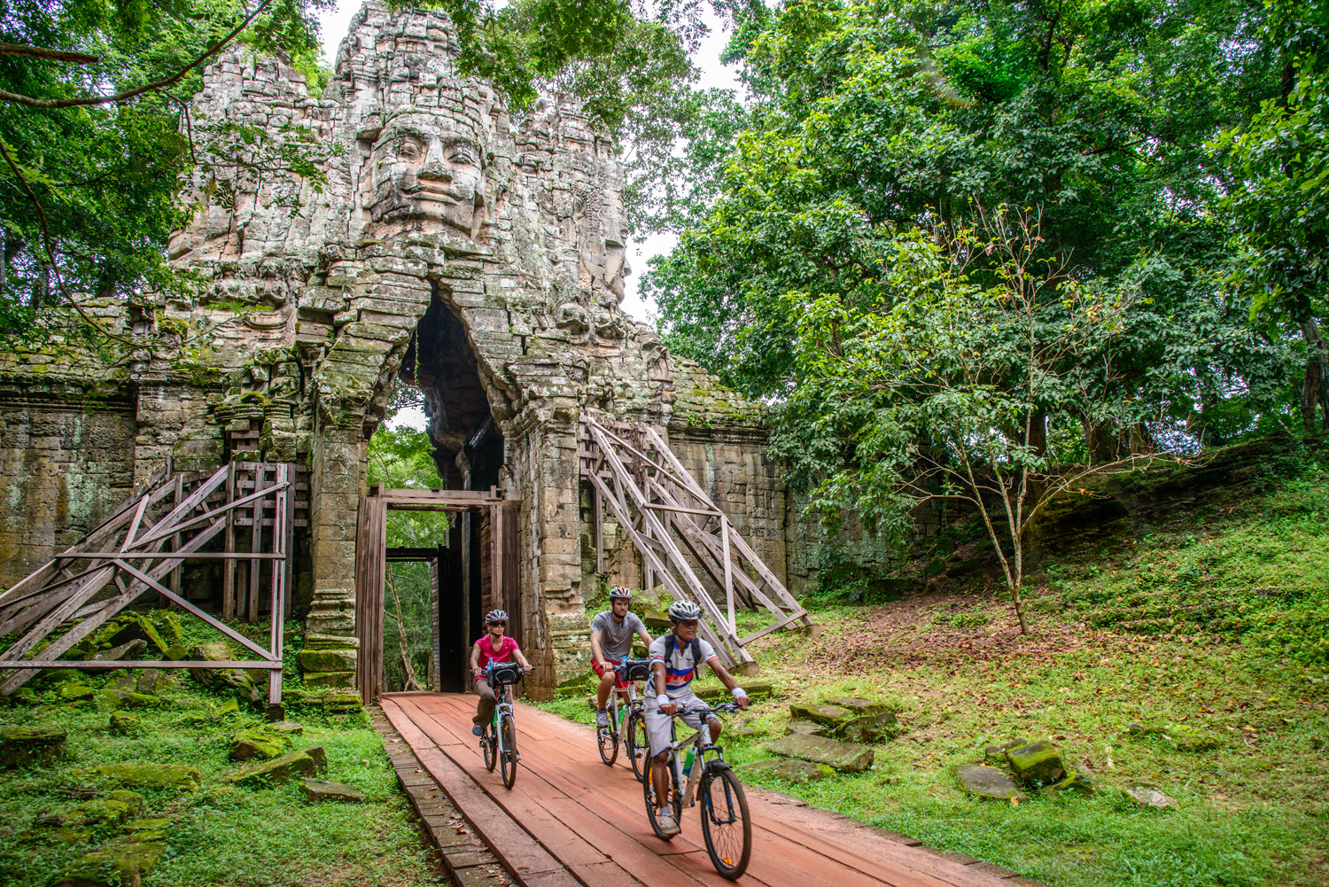 Travelers biking through Angkor. (Photo courtesy of Grasshopper Adventures.)