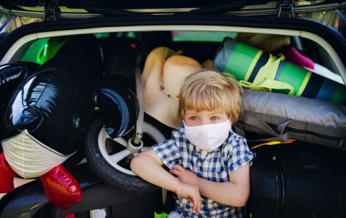 small-boy-with-face-mask-sitting-in-loaded-car-boo-743P9NS florida